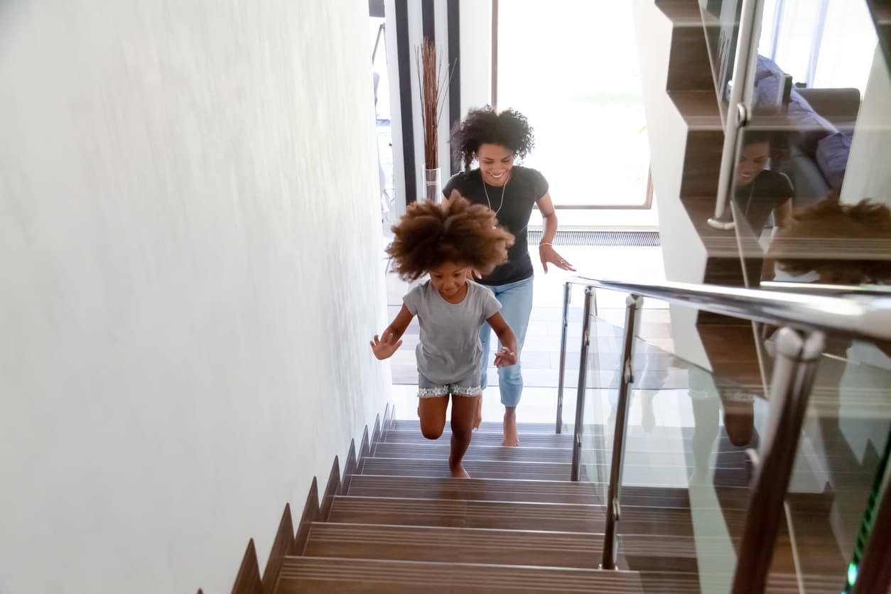 Mum and daughter walk up staircase